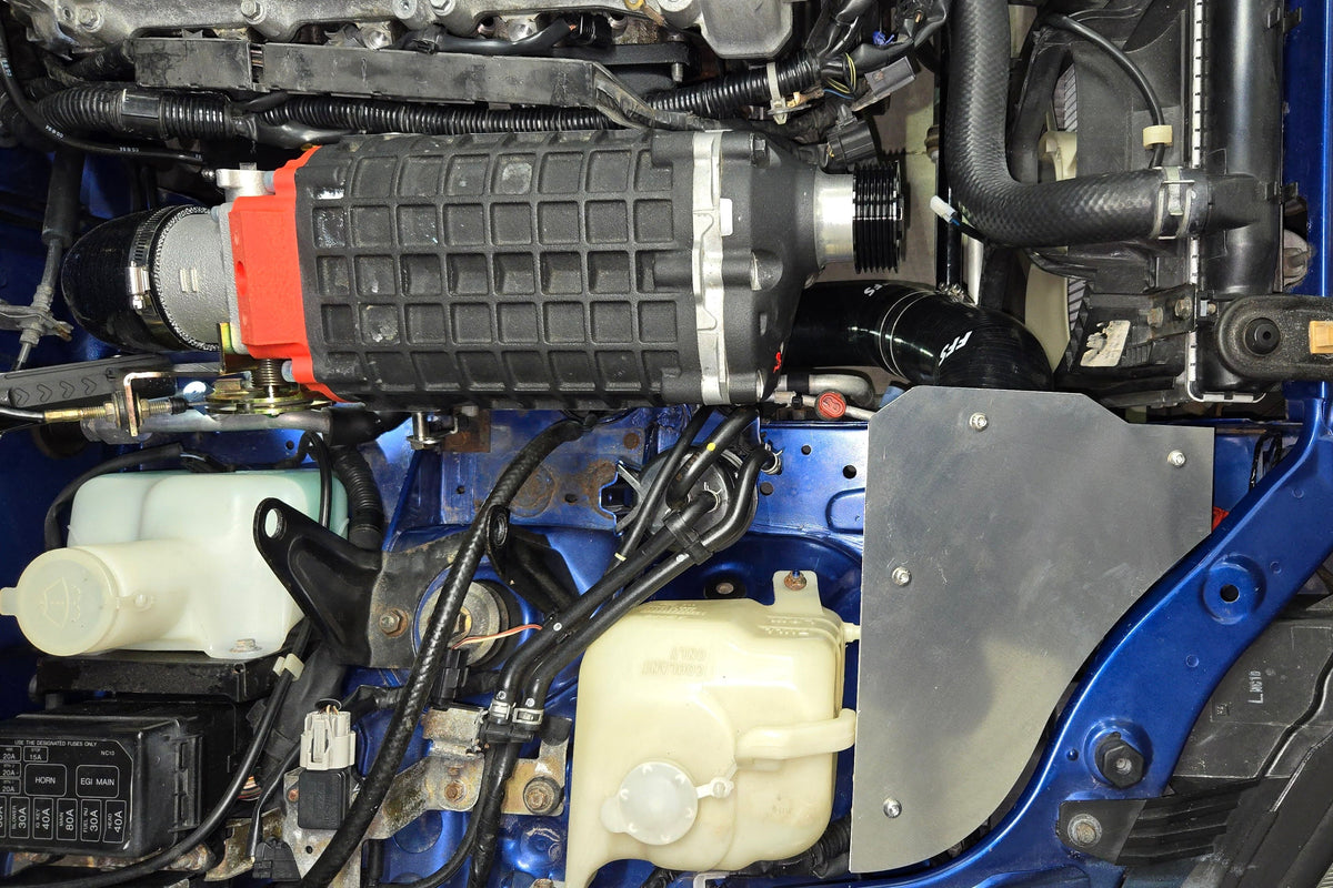 1999–2005 Miata engine-bay view showing the supercharger and covered cold-air intake enclosure