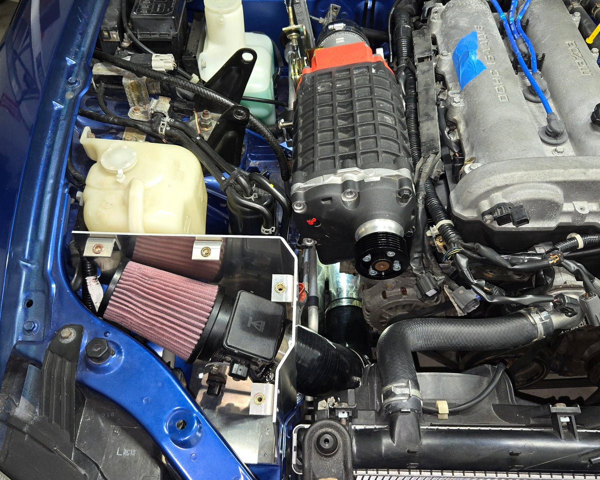 Wide 1999–2005 Miata engine-bay view with the coldside cone filter exposed beside the supercharger