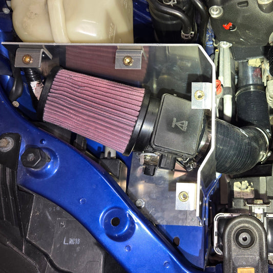 Coldside cold-air intake installed in a 1999–2005 Miata, close overhead view of the cone filter, airflow meter, and aluminum enclosure