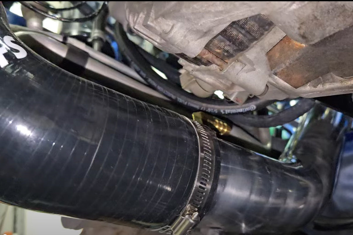Underside view of the cold-air intake tube installed beneath the alternator